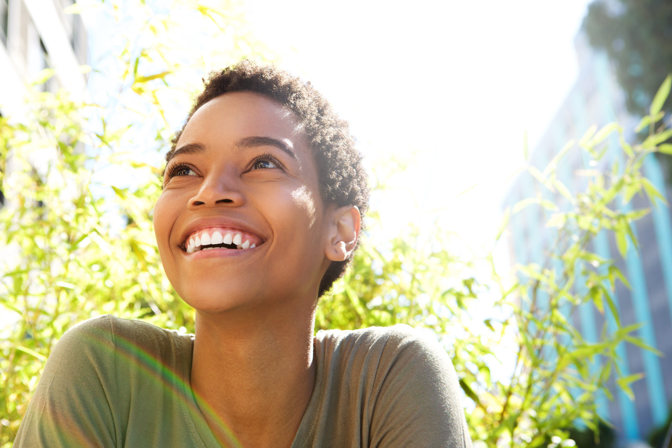 Young woman smiling outdoors with healthy teeth